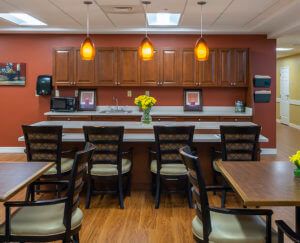 A cozy kitchen dining area with wooden chairs, a countertop, and warm lighting.