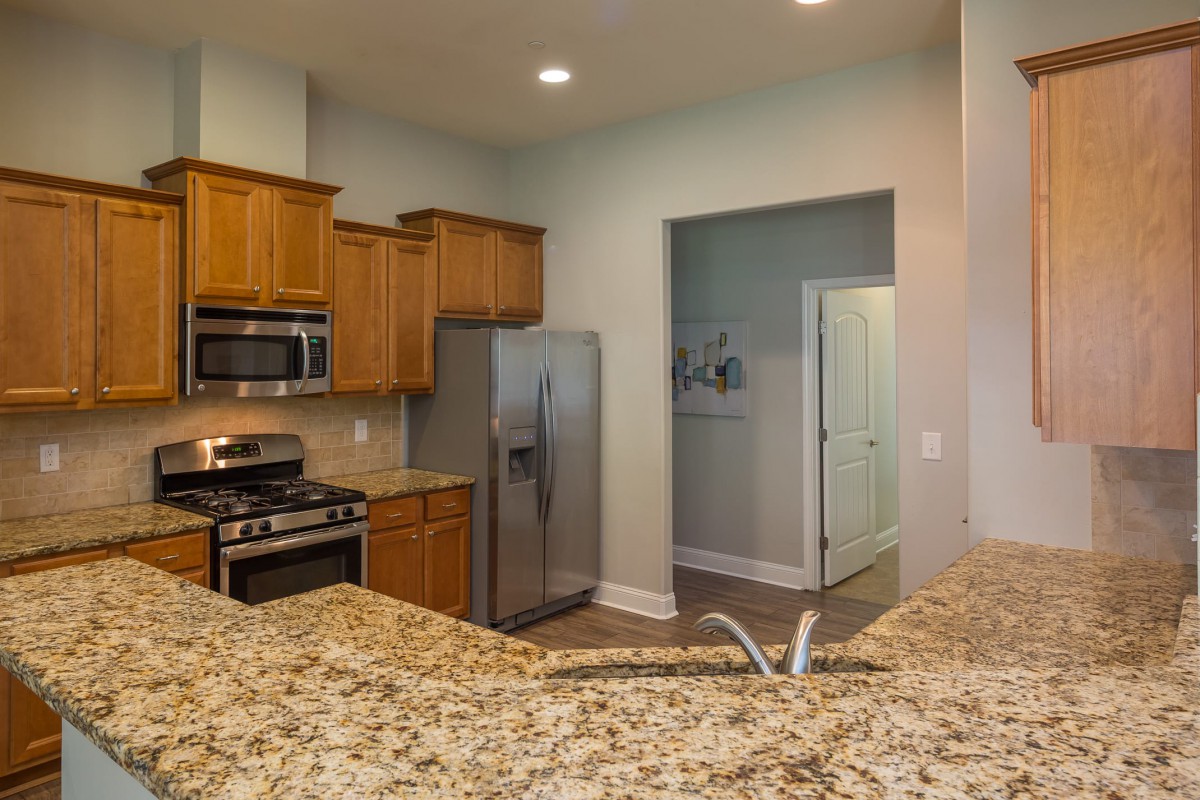 A modern kitchen with granite countertops and stainless steel appliances.