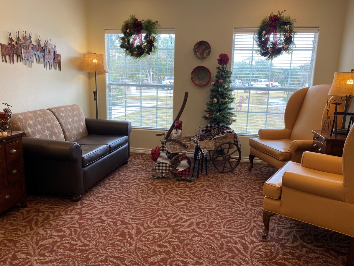 A cozy living room decorated for the holidays with a Christmas tree and wreaths.