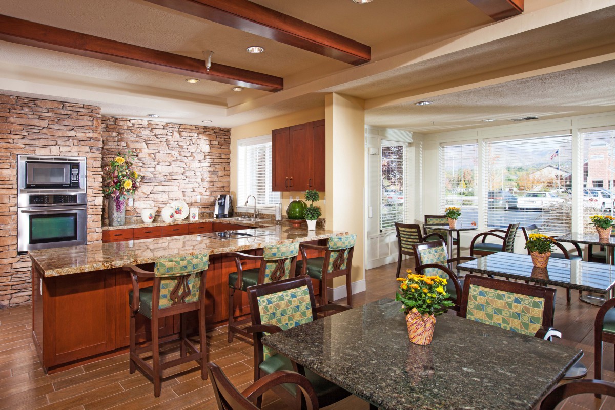 A modern kitchen and dining area with wooden beams, a bar, and ample natural light.