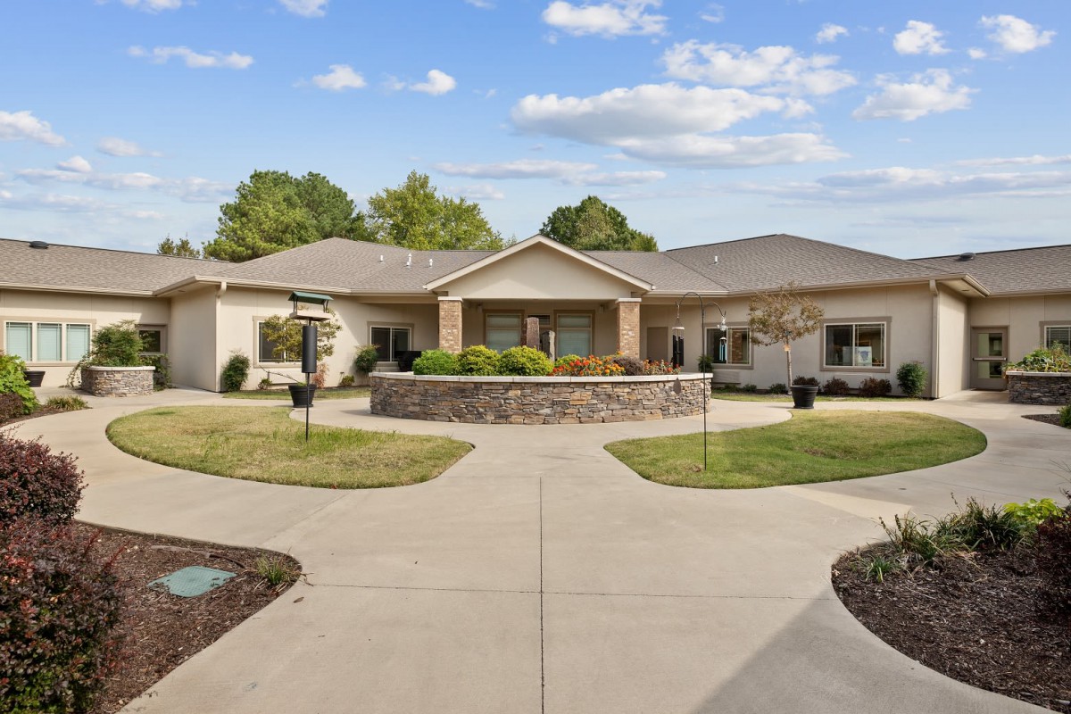 A suburban house with a circular driveway and landscaped front yard.