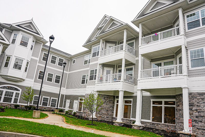 A modern residential apartment building with multiple balconies and a white exterior.