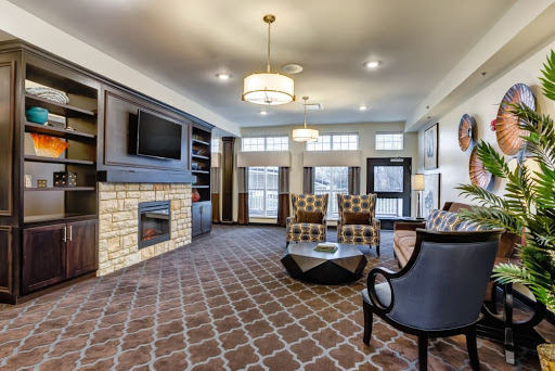 A modern living room featuring comfortable furniture, a stylish fireplace, and ample natural light.
