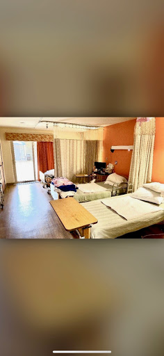 A well-lit hospital room equipped with multiple patient beds and a comfortable environment.