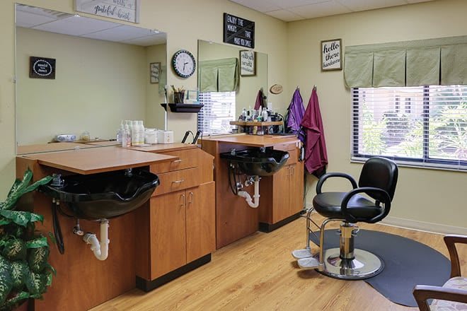 An interior view of a hair salon with styling stations, mirrors, and chairs.