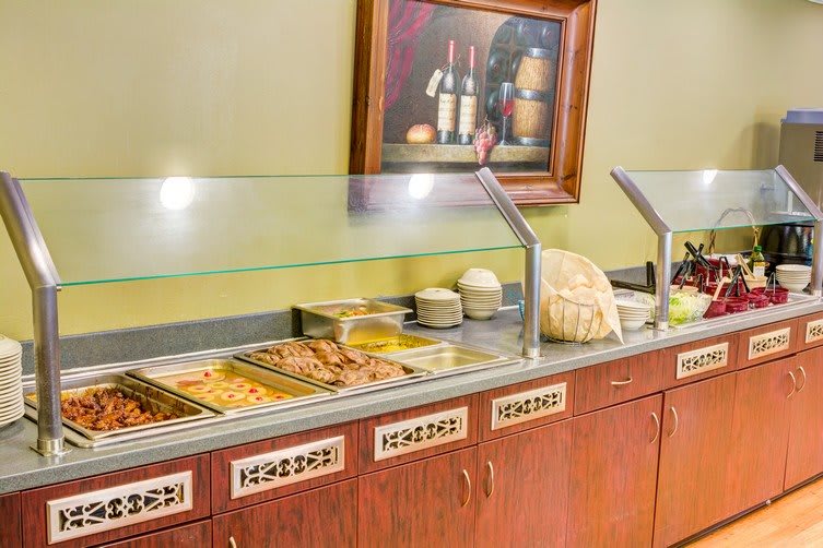 A hotel breakfast buffet with a variety of dishes displayed.