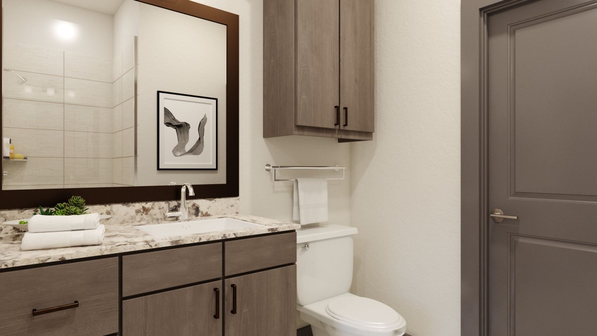 A modern bathroom with a sink, toilet, and wooden cabinetry.
