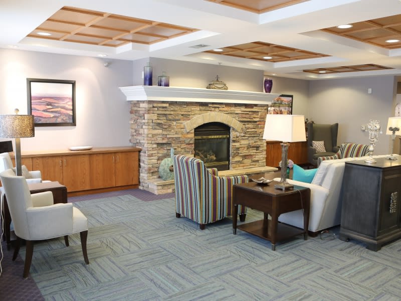 A cozy living room with a stone fireplace and comfortable seating.