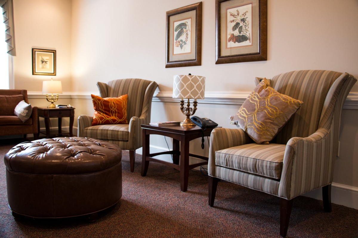 A cozy living room with two armchairs, decorative pillows, and wall art.