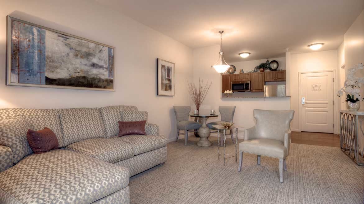 A cozy living room with a patterned sofa, dining table, and subtle interior decor.