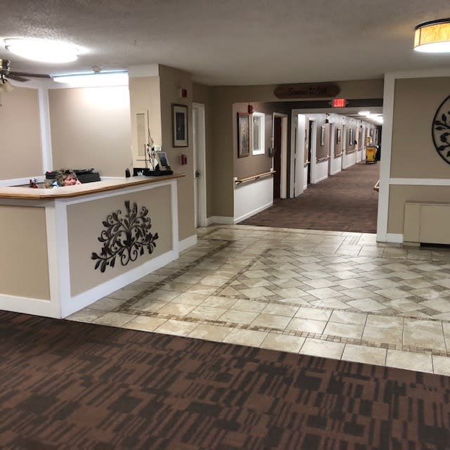 A spacious hotel lobby with a reception desk and a long hallway.