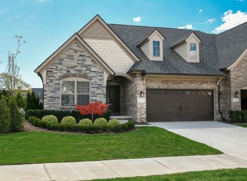 A suburban house with a stone facade and well-maintained front yard.