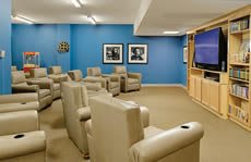 A cozy home theater room with comfortable seating and a big screen.