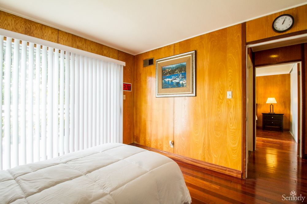 A cozy bedroom with wood paneling and minimalist decor.