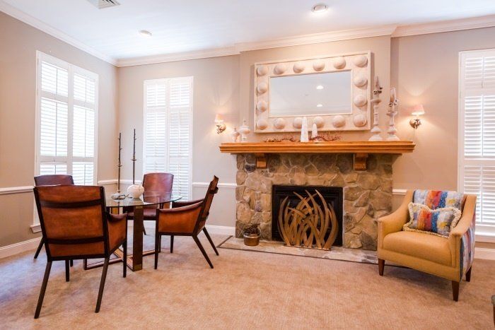 A cozy living room featuring a stone fireplace, dining set, and elegant decor.