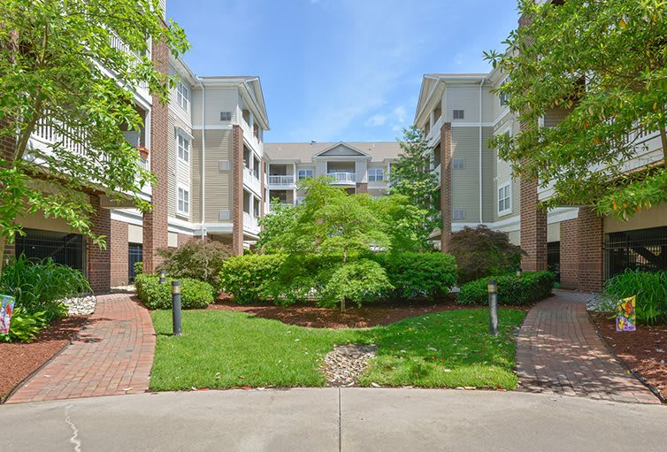 A residential apartment complex with well-maintained landscaping and greenery.