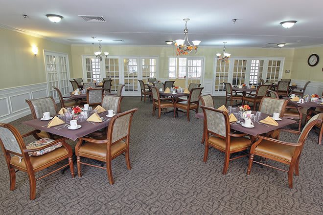 A spacious dining room with neatly arranged tables and chairs, ready for guests.