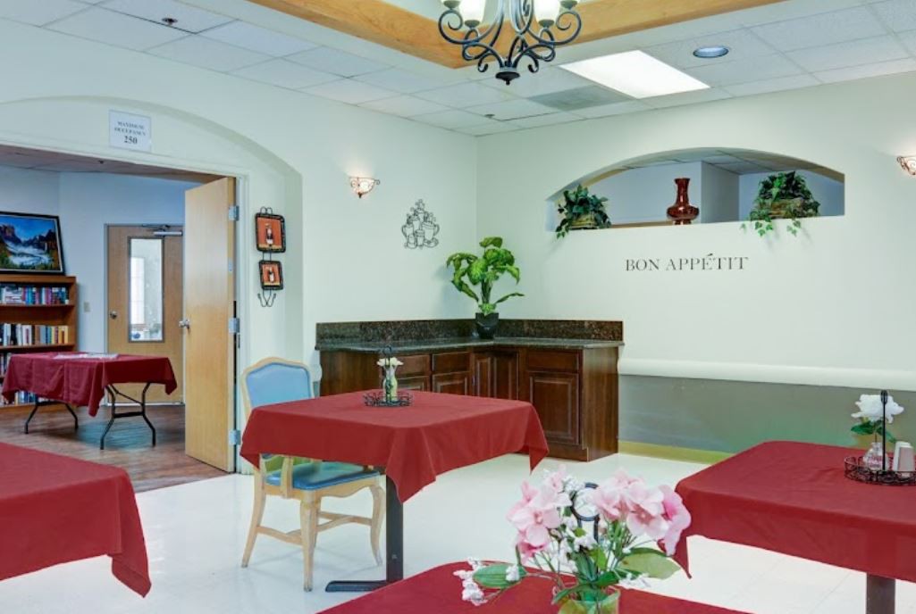 A modern dining area with red tablecloths and decorative plants.