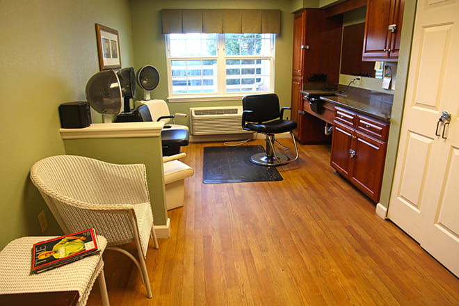 A cozy hair salon interior with stylish seating and equipment.