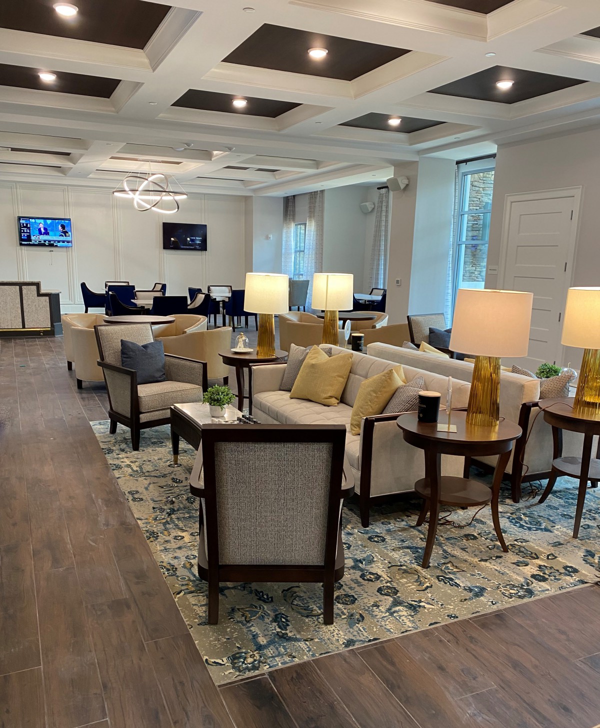 A modern, comfortable lobby area featuring sofas, armchairs, and table lamps.