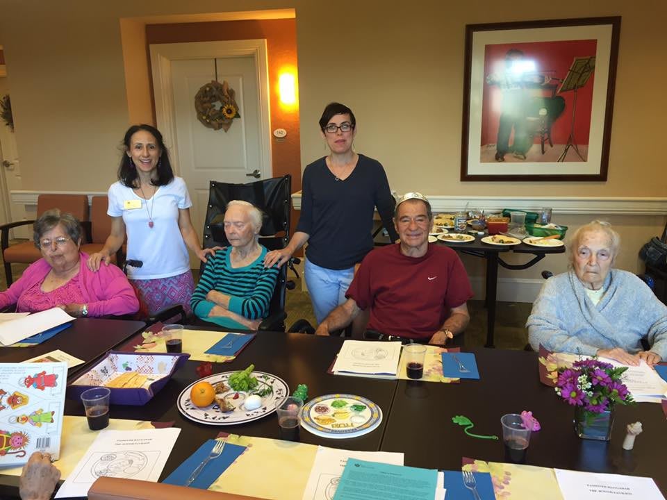 A family gathering around a dining table, enjoying food and each other's company.