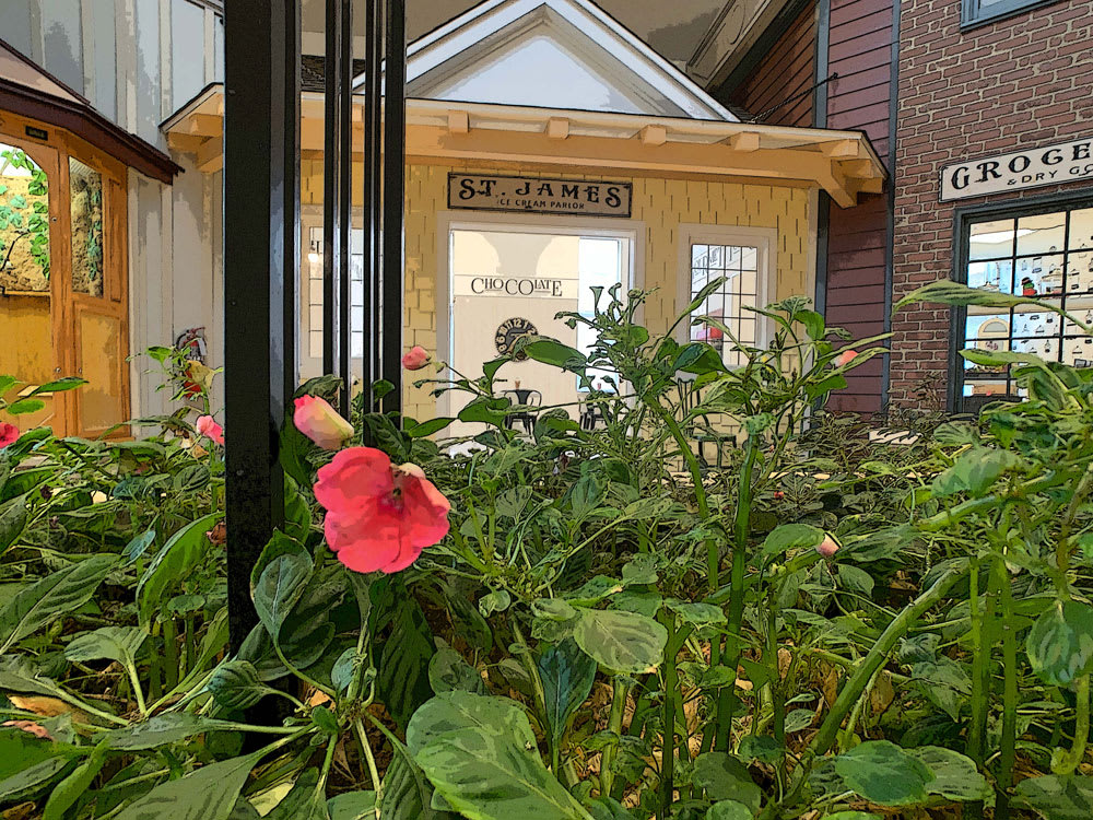 A cozy wooden building surrounded by lush greenery and vibrant flowers.