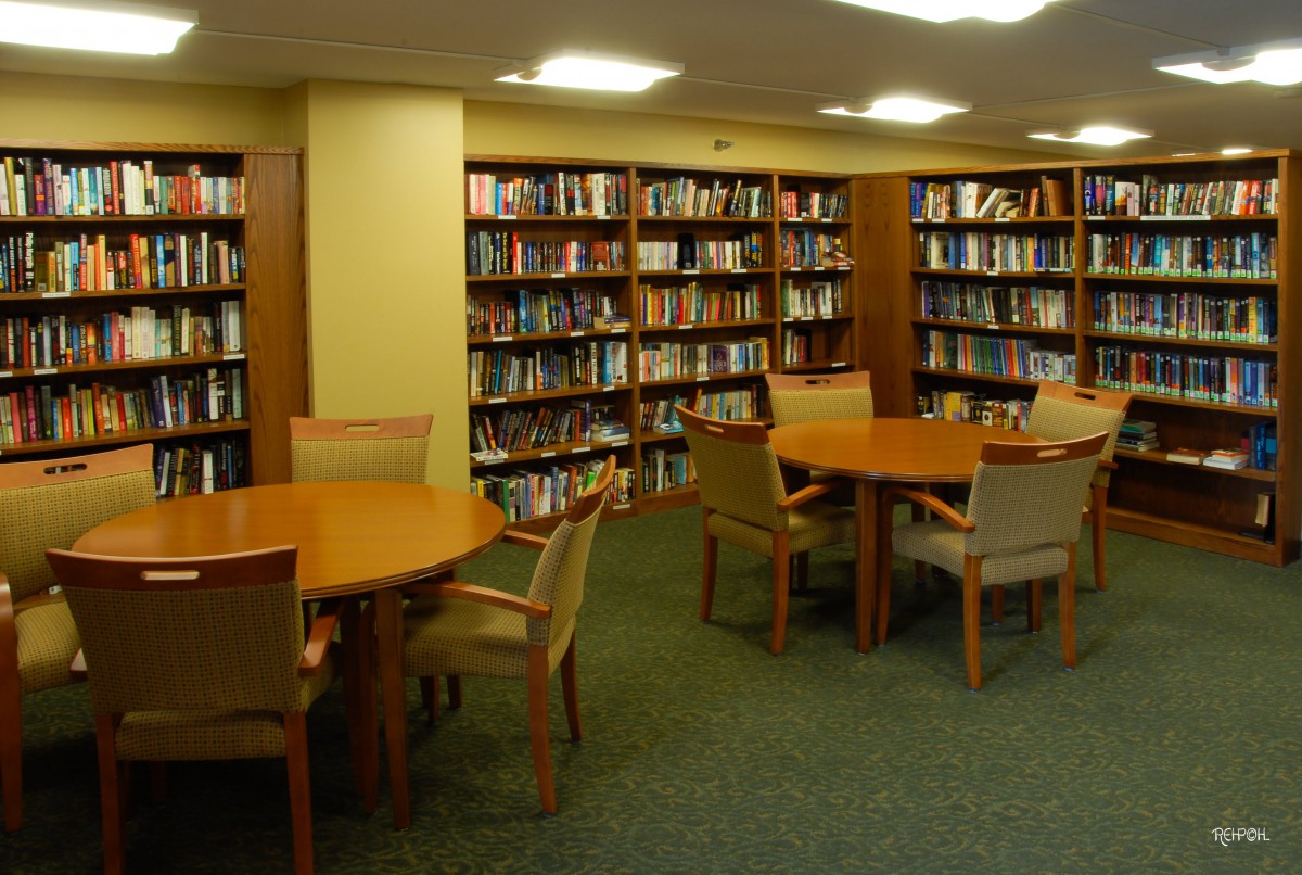A quiet library reading area with tables and bookshelves.
