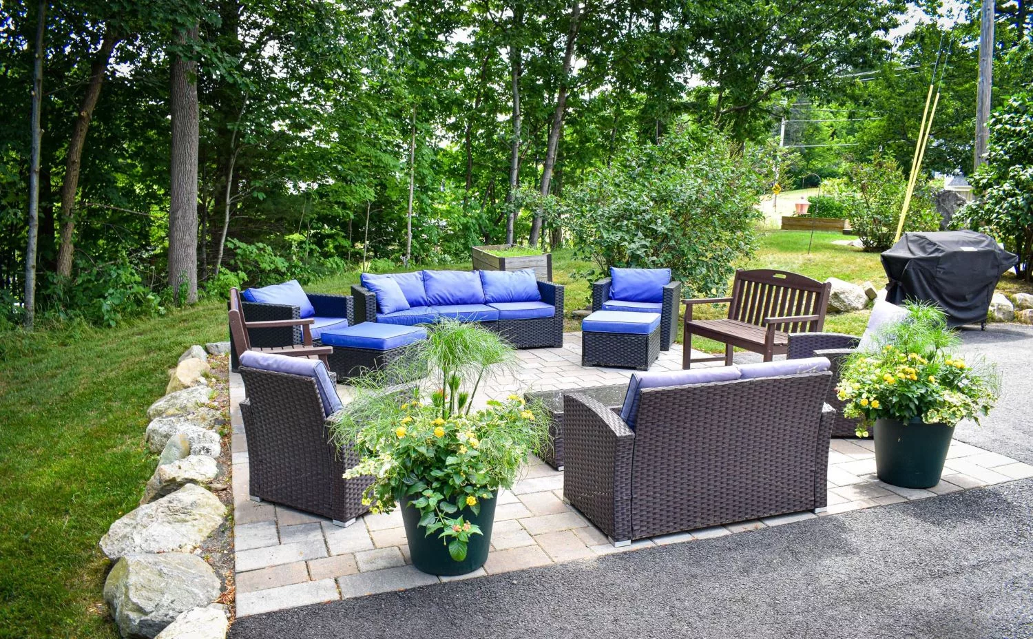 A cozy outdoor patio with comfortable furniture and lush greenery.