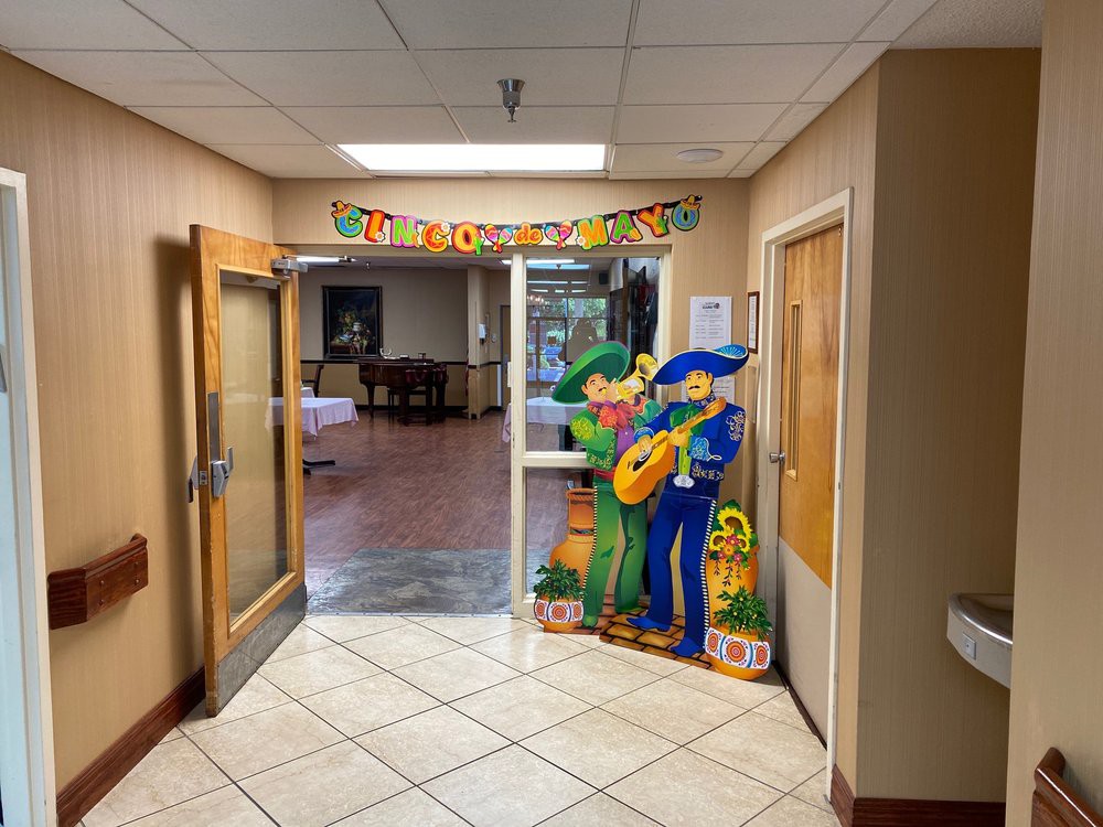 A decorated hallway entrance with colorful cardboard cutouts and a festive banner.