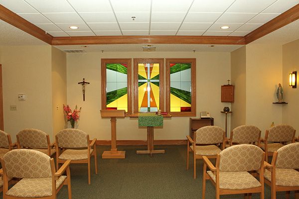 A small chapel with stained glass windows and an altar.