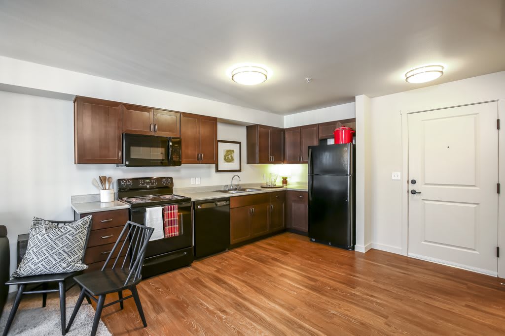 Modern kitchen with wooden cabinets and hardwood flooring.