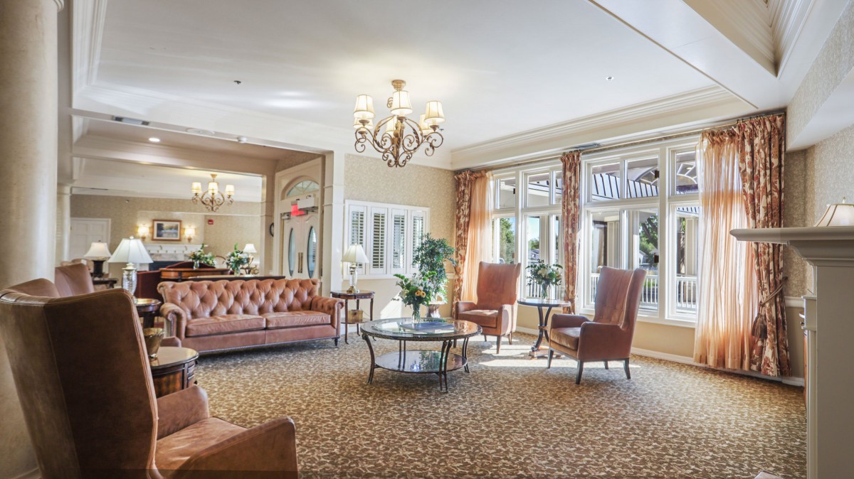 A luxurious lobby with comfortable seating, elegant chandelier, and large windows.