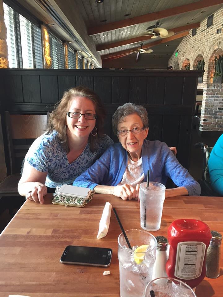 Two people smiling at a restaurant table.
