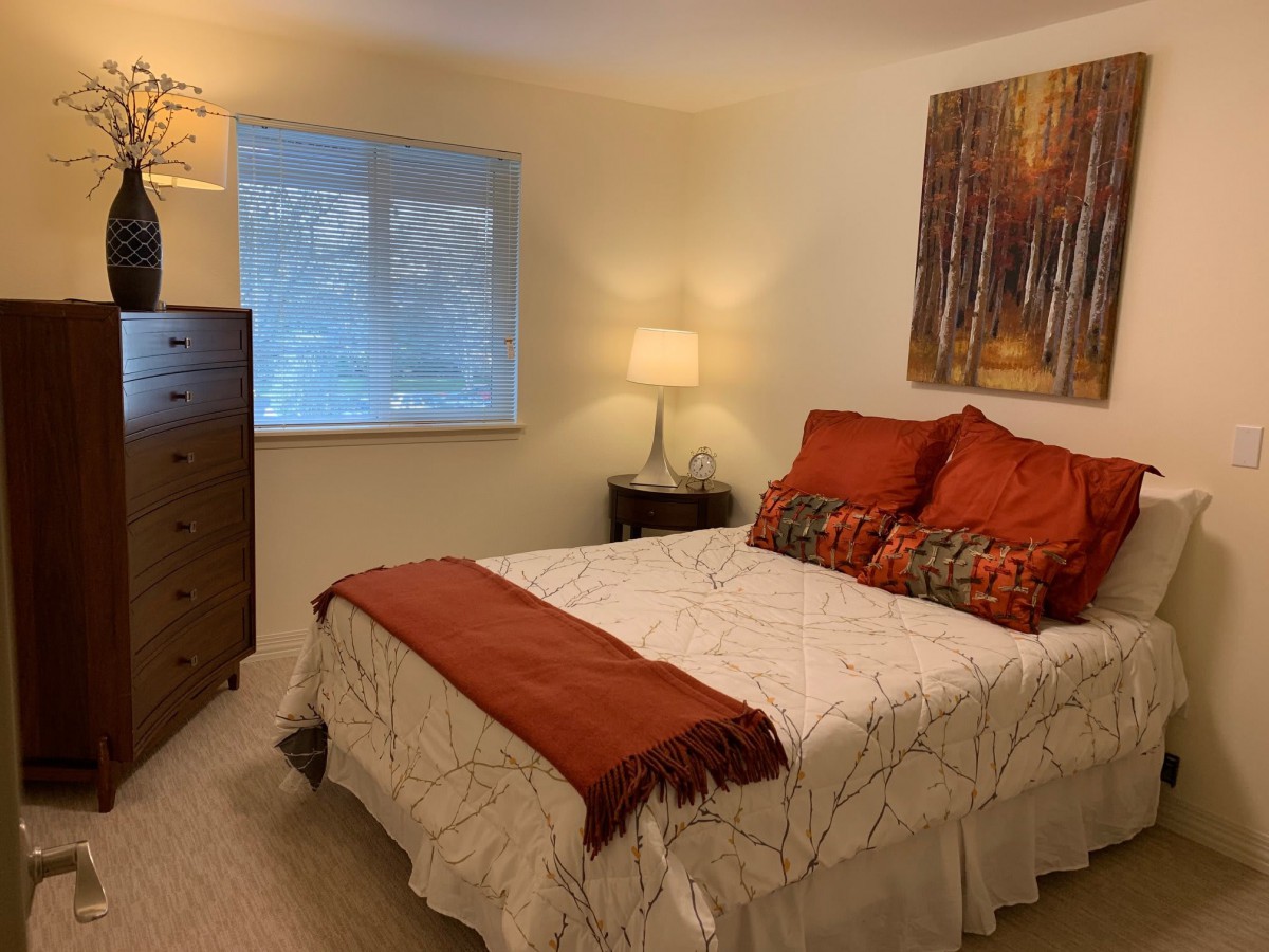 A cozy bedroom with warm-toned decor and soft lighting.