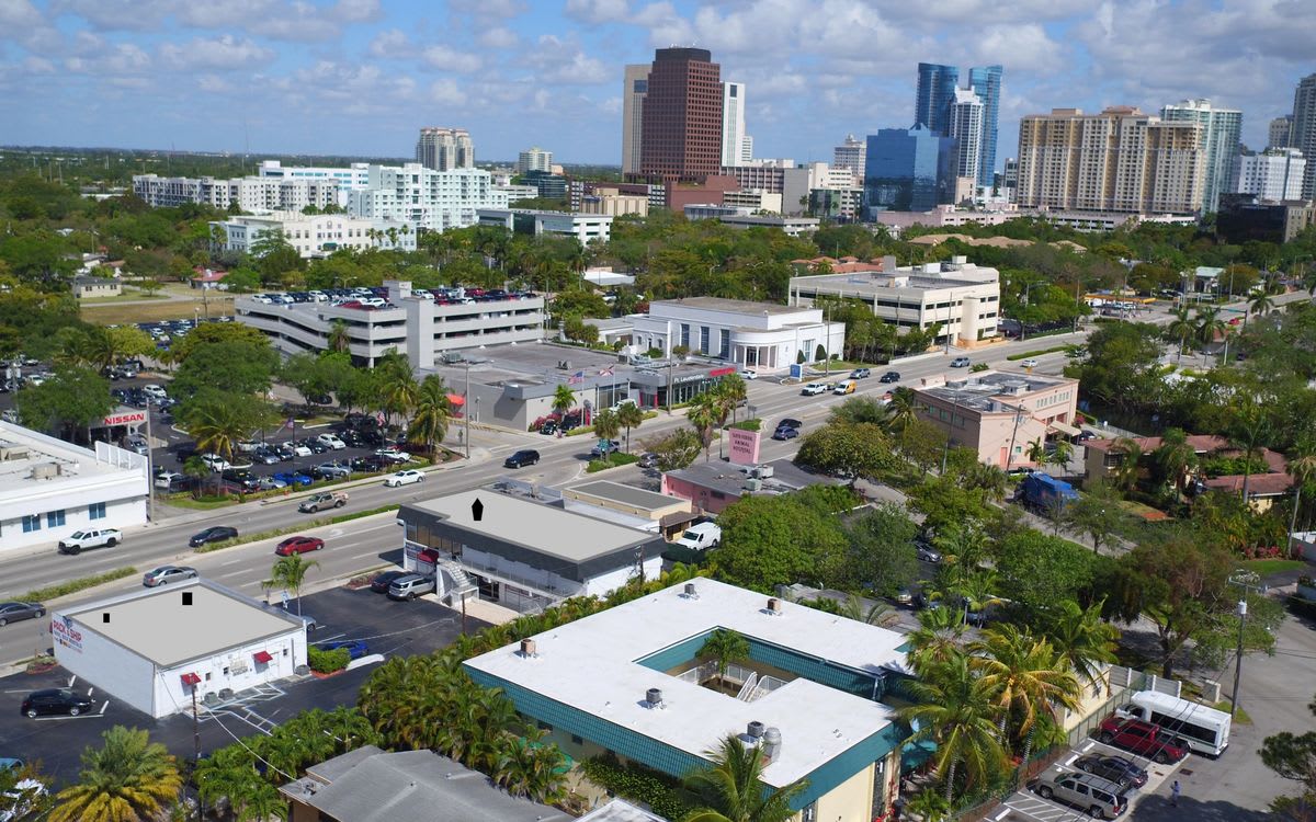Aerial view of a cityscape with buildings and a clear blue sky.