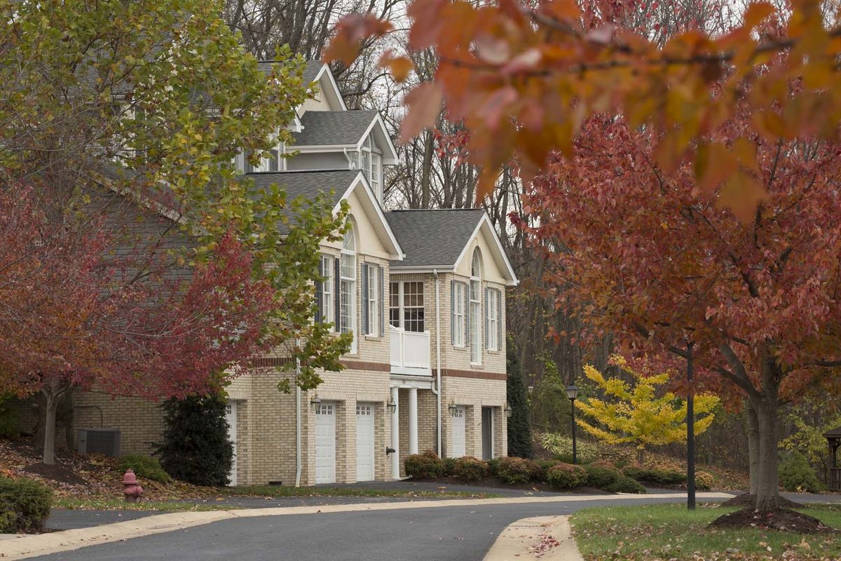A suburban house surrounded by autumn foliage.