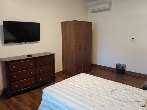 A neatly arranged bedroom featuring essential furniture, including a TV and wardrobe.