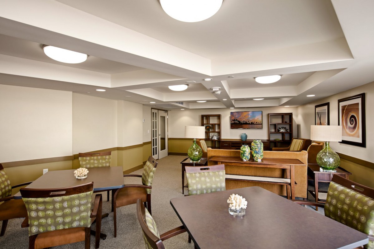 A modern interior room with tables, chairs, and decorative elements.