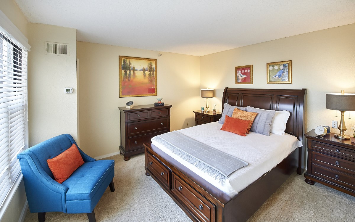 A cozy bedroom with modern furniture and colorful artwork.