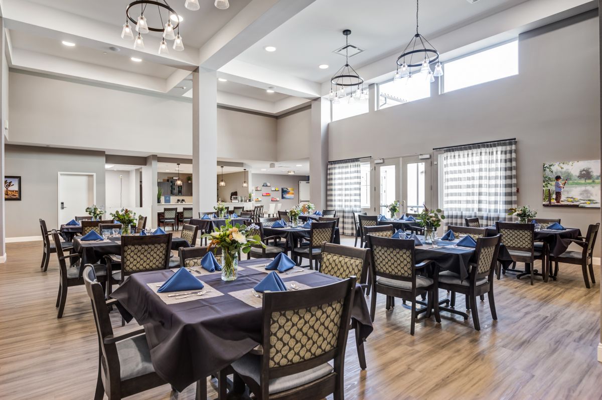 An elegant dining room with neatly arranged tables and chairs, featuring stylish lighting and decor.