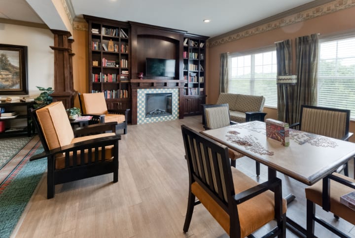 A cozy living room with a fireplace, bookshelves, and comfortable seating.
