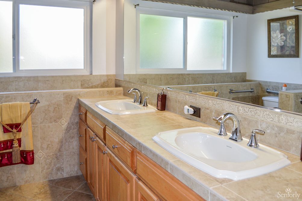 A modern bathroom featuring a double sink vanity with ample countertop space and a large mirror.