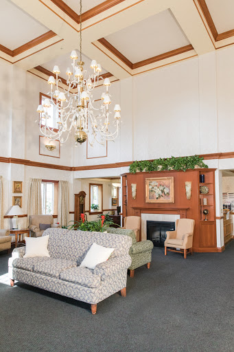 A cozy and elegant lobby featuring a chandelier, tasteful furniture, and a warm atmosphere.