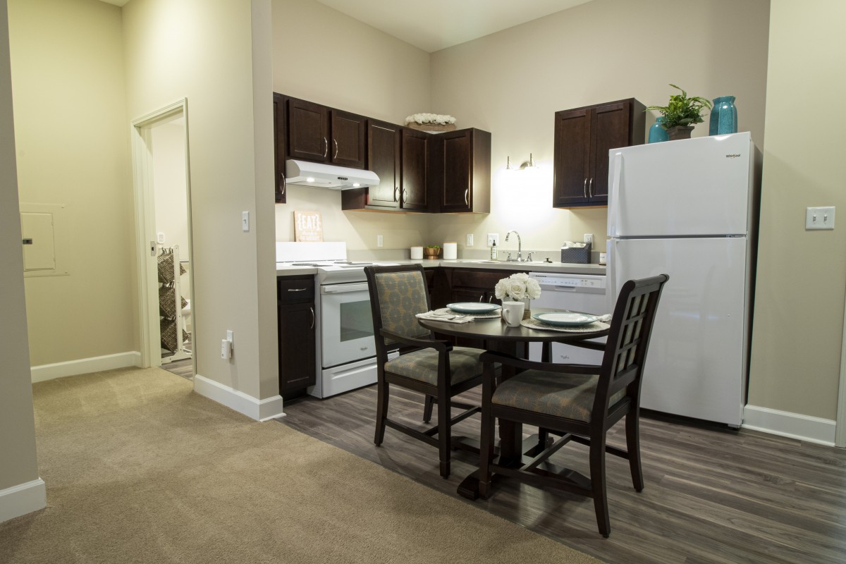 A cozy apartment kitchen with a dining table and modern appliances.