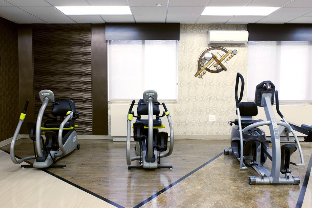 A modern gym with various exercise machines lined up in a bright and spacious room.