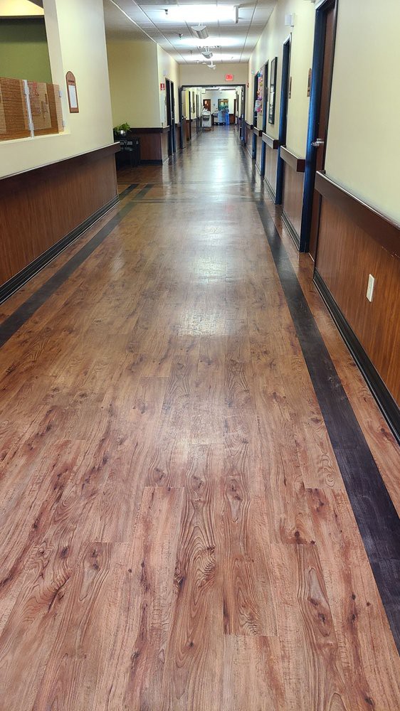 A long hallway with wooden flooring and lined walls.