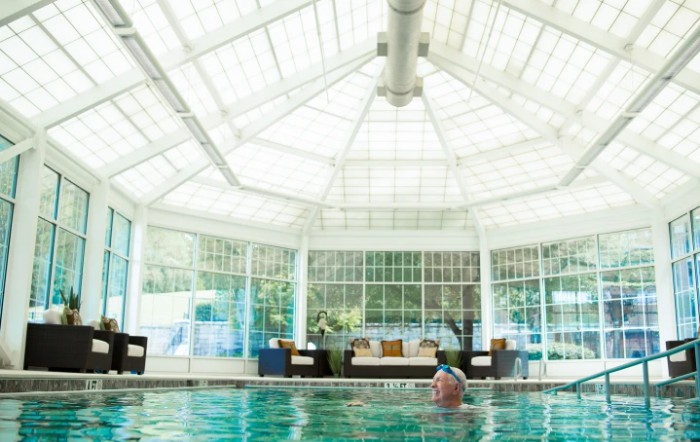 A serene indoor pool with a glass ceiling letting in natural light.