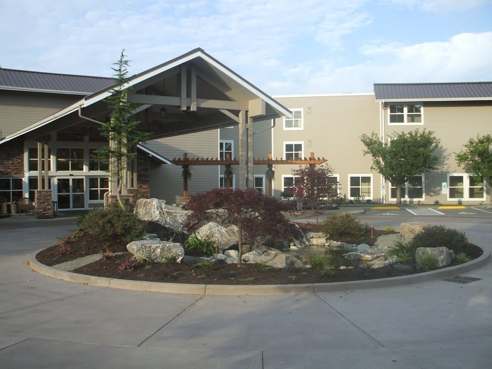 A modern building entrance with landscaped surroundings.