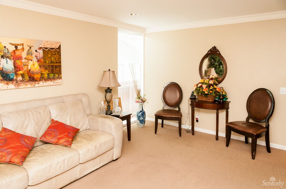 Cozy living room with a sofa, chairs, a table with decorative items, and a lamp.