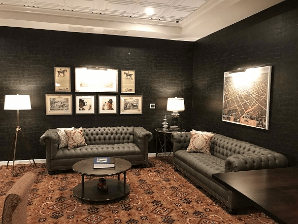 A stylish living room with dark walls, plush sofas, and cozy lighting.